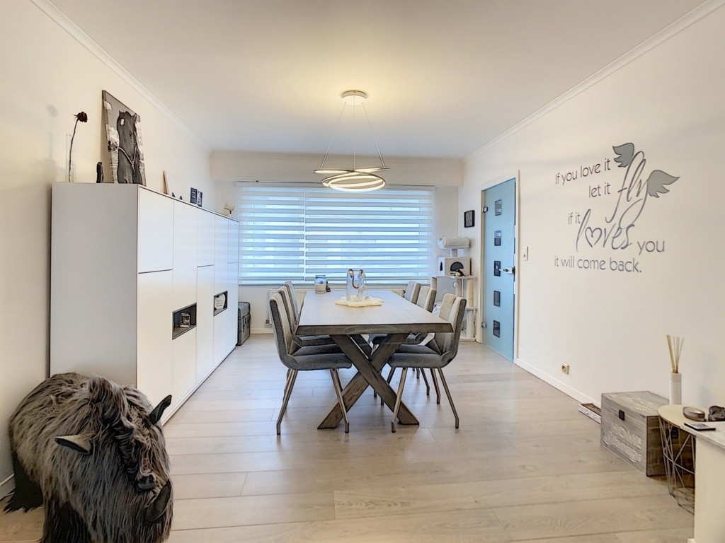 Salle à manger moderne, minimaliste, lumineuse, avec mobilier en bois clair, décoration artistique et ambiance chaleureuse.