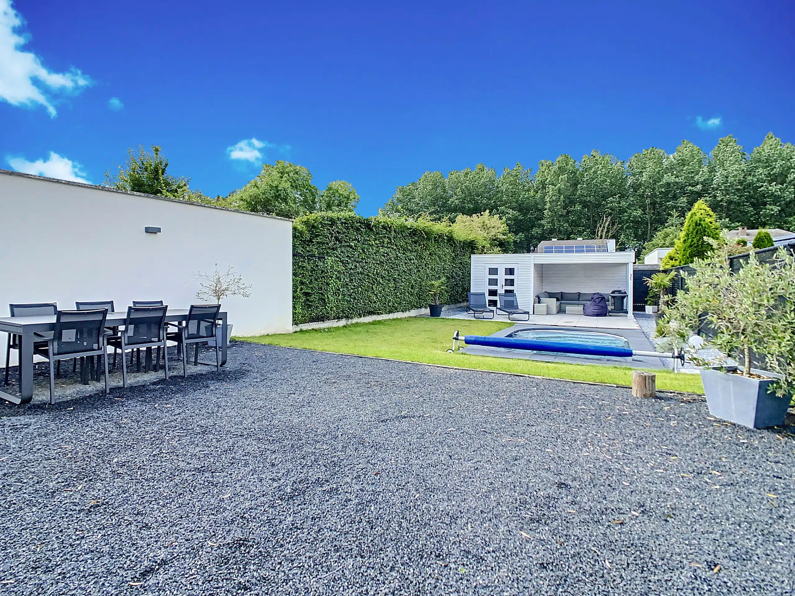 Près de la piscine, un salon d'extérieur dans un bel abri bois