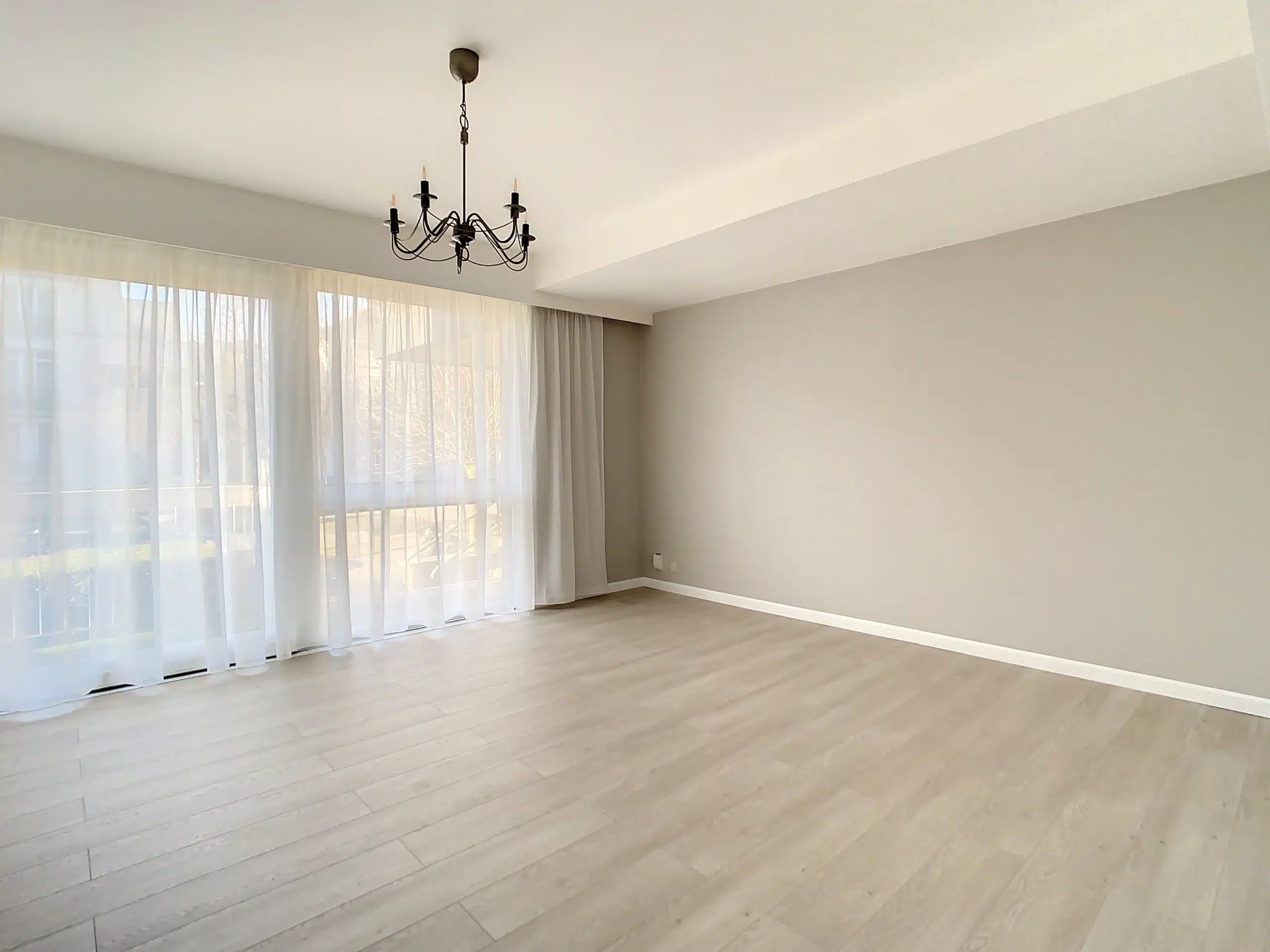 Salon Élégant et Lumineux avec Chandeliers et Vue Naturelle Salon - Lumineux appartement 1ch avec terrasse – Watermael-Boitsfort