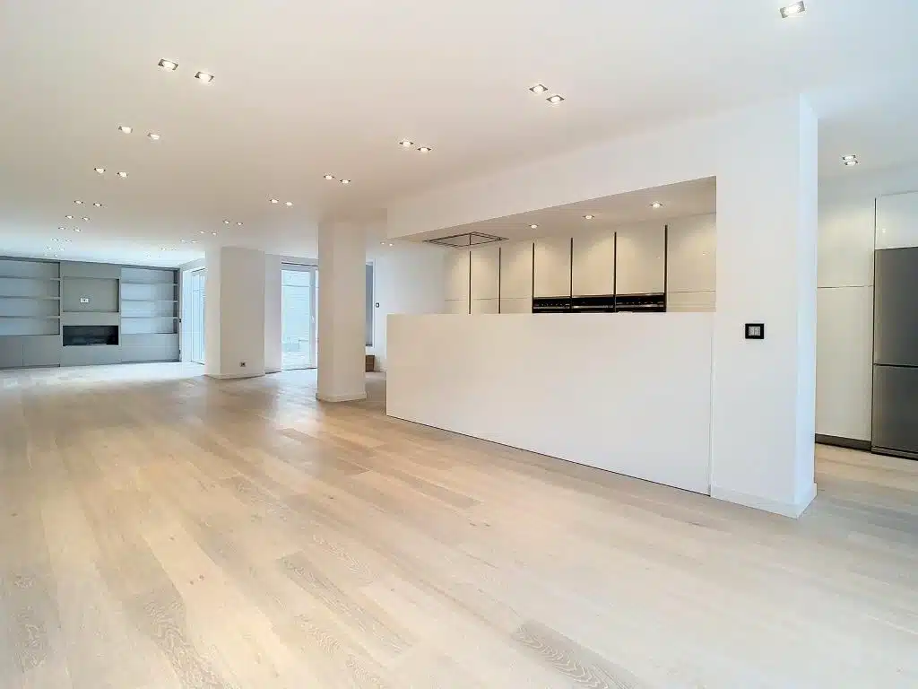 Modern living room with open kitchen and stone wall Kitchen - Exceptional apartment with patio - Abbaye de la Cambre - Ixelles