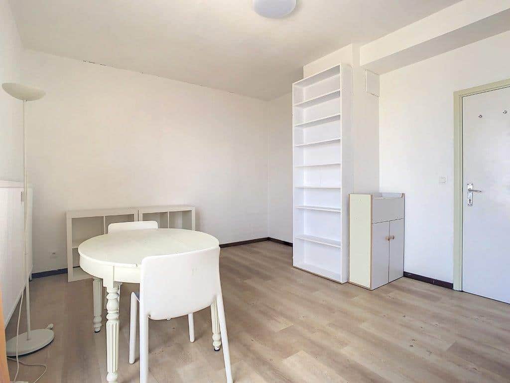 Salon minimaliste lumineux, mobilier blanc, ambiance épurée, idéal pour détente ou travail.