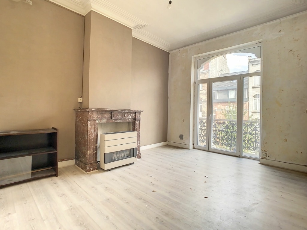 Salon moderne et lumineux avec cheminée, meuble TV minimaliste et grande fenêtre naturelle.