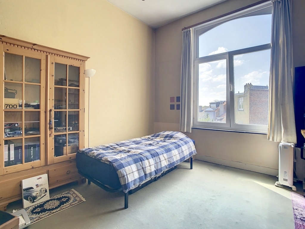 Salon chaleureux avec décoration rustique, vue urbaine, mobilier moderne et ambiance cosy.