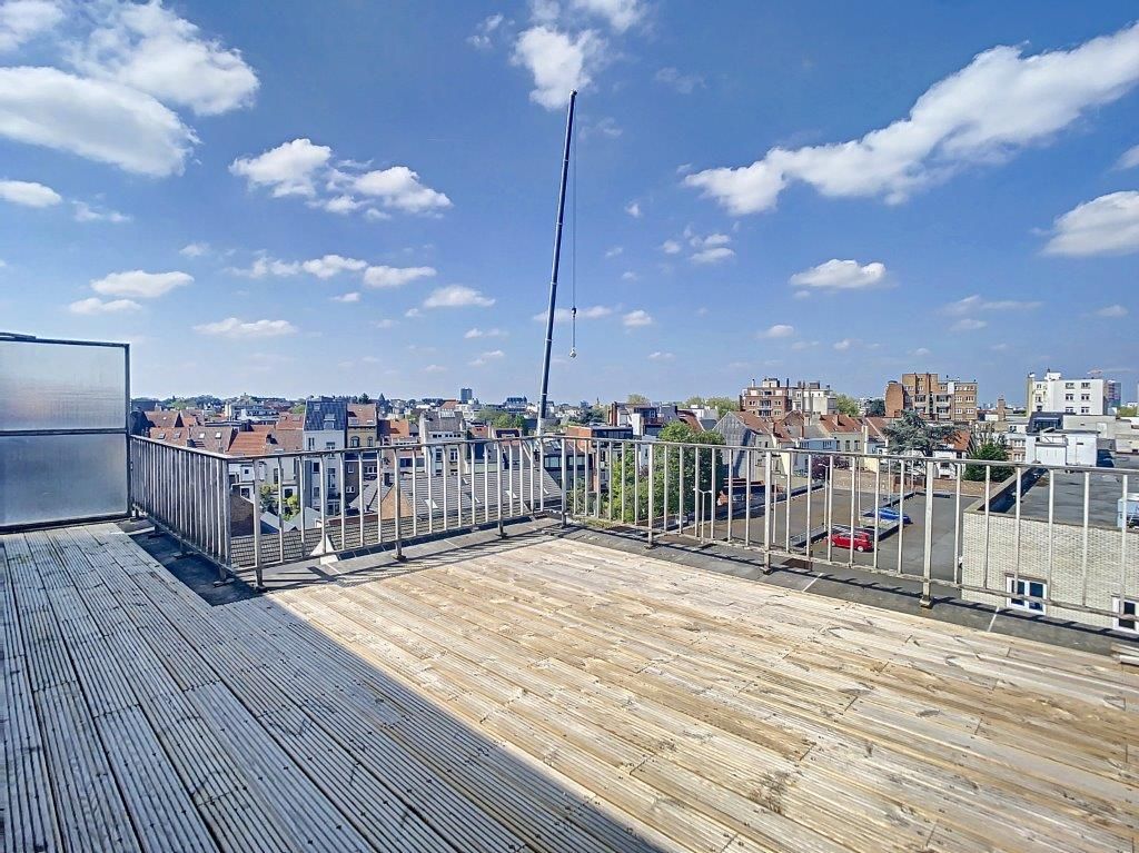Vue rooftop à Belo Horizonte avec terrasse en bois et ciel bleu lumineux.