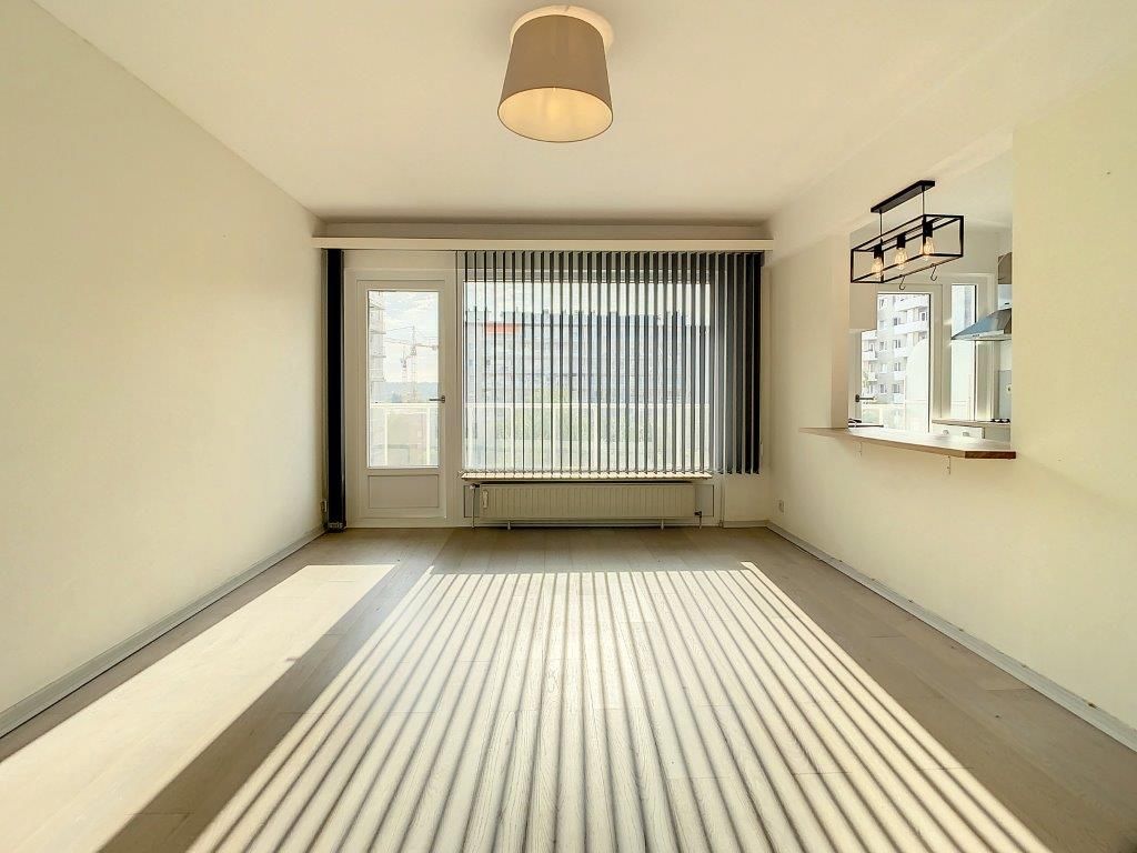 Espace intérieur lumineux et minimaliste avec fenêtre, éclairage moderne et zone bar pratique.