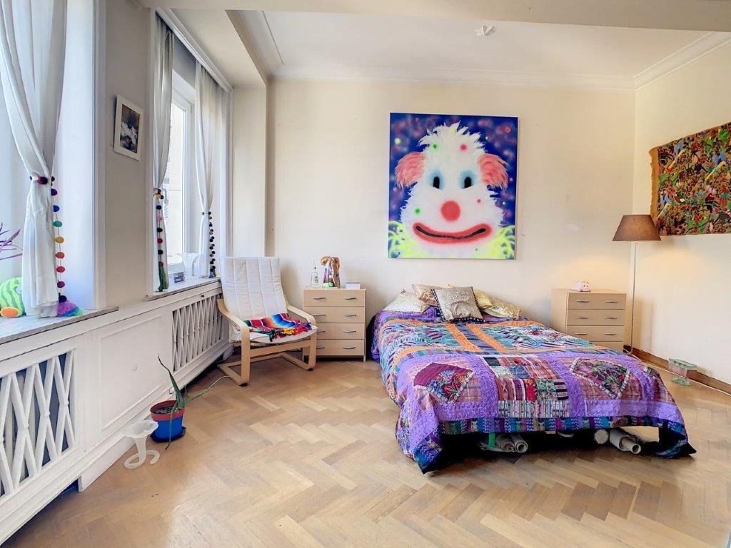 Chambre colorée et cosy avec art ludique, mobilier minimaliste et ambiance chaleureuse.