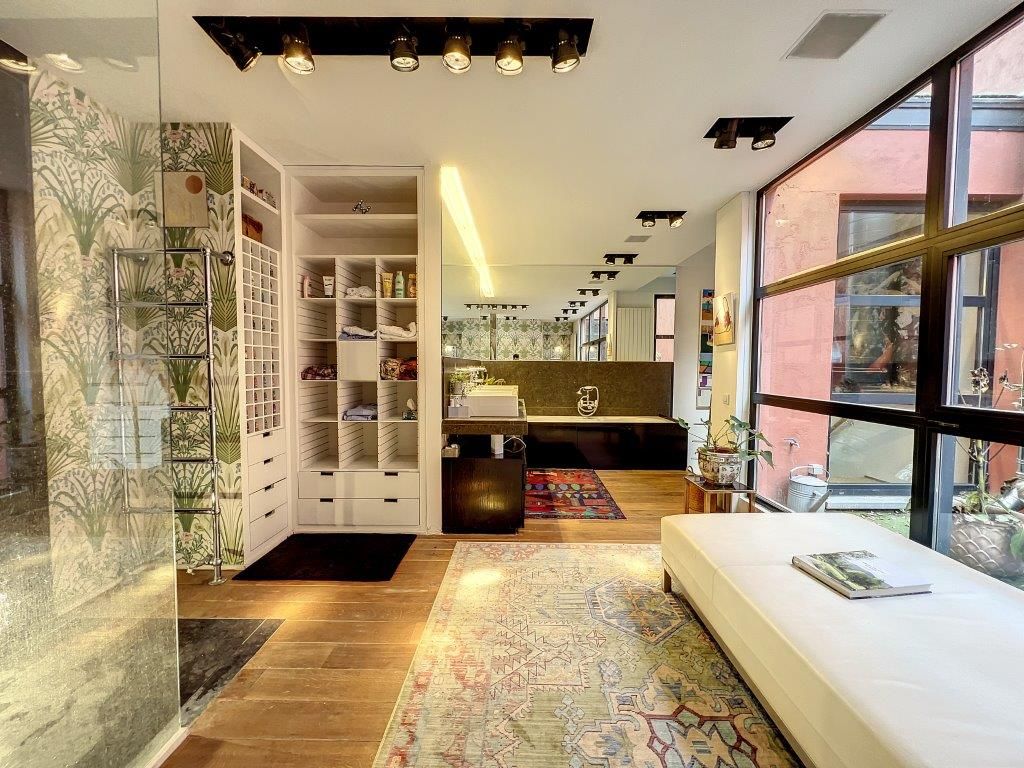 Intérieur moderne lumineux avec espace détente, bureau organisé, plantes et design épuré.