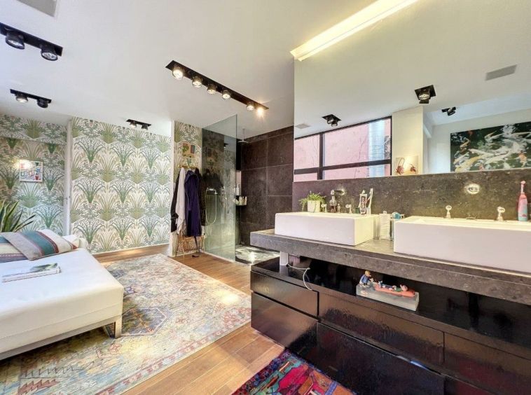 Salle de bain élégante avec douche en verre, double vasque, espace détente cosy et design moderne.