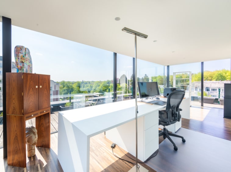 Bureau lumineux moderne avec vue panoramique, mobilier épuré, ambiance élégante et chaleureuse.