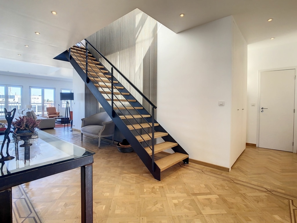 Escalier moderne en bois et métal dans un appartement en duplex lumineux avec parquet et mobilier contemporain
