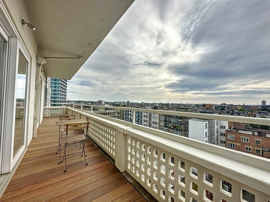 Balcon moderne avec vue panoramique urbaine, mobilier élégant et ambiance relaxante.