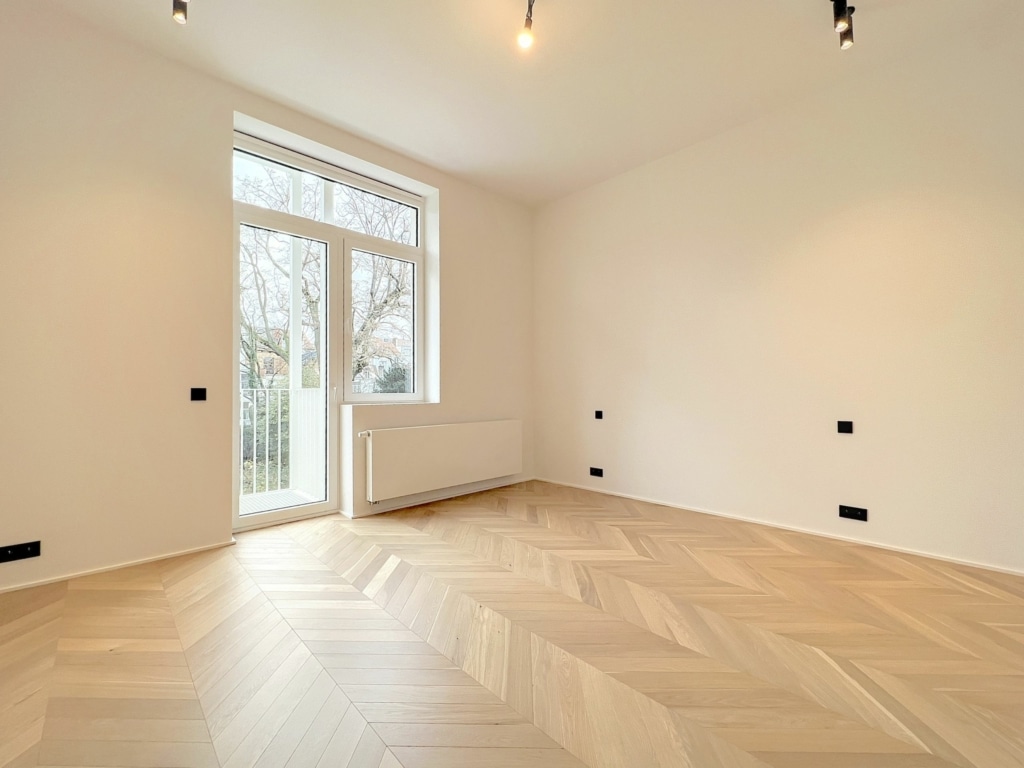 Espace intérieur moderne lumineux avec parquet en chevron et grandes fenêtres, prêt à personnaliser.