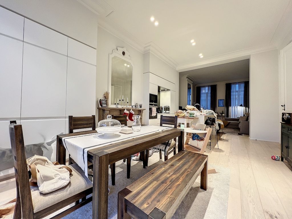 Salle à manger moderne avec table en bois, lumière naturelle et espace ouvert convivial.