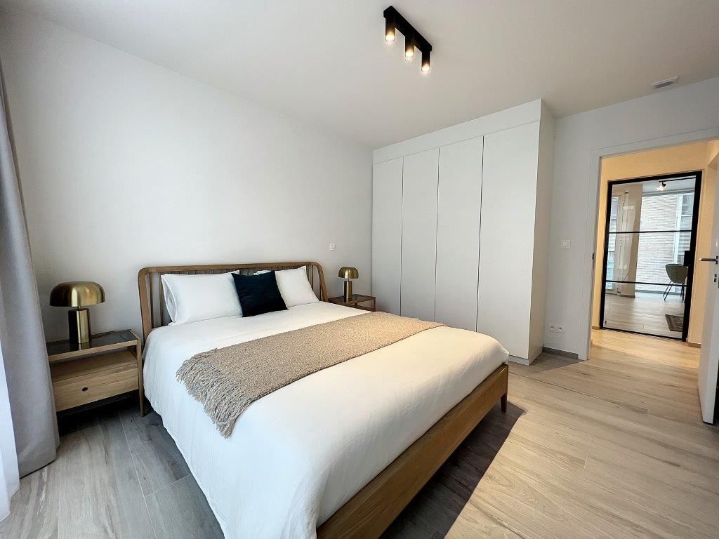 Chambre minimaliste élégante avec lit blanc, décoration épurée, lumière naturelle et ambiance apaisante.