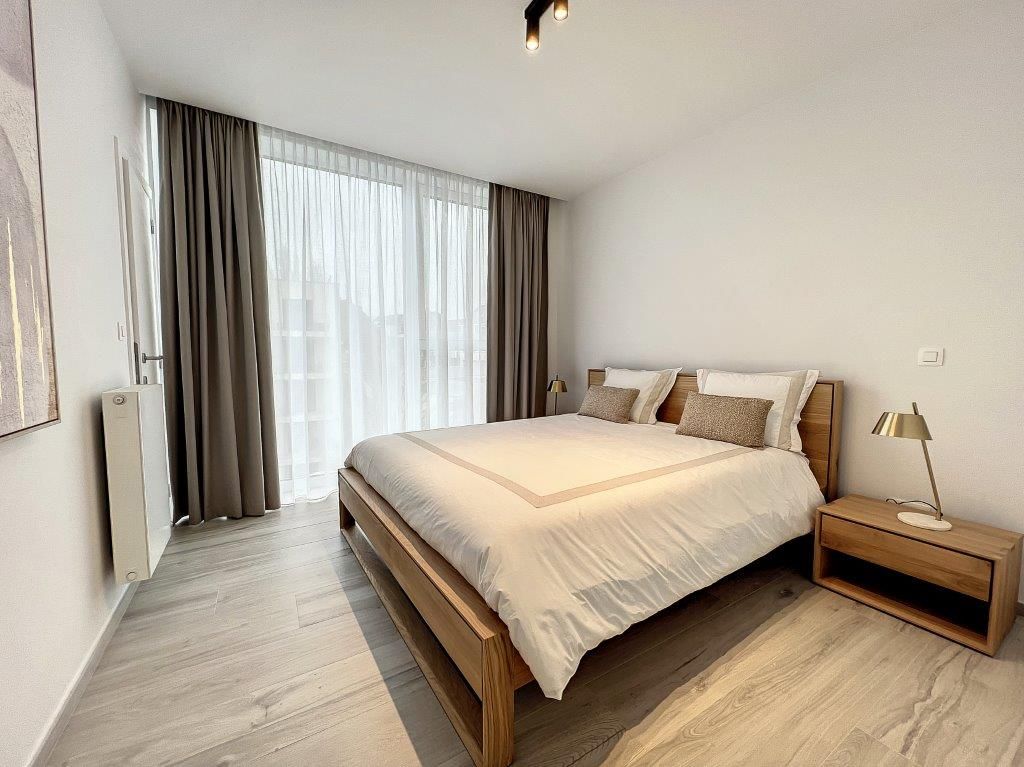 Chambre moderne minimaliste, lit en bois, lumière naturelle, ambiance calme et chaleureuse.