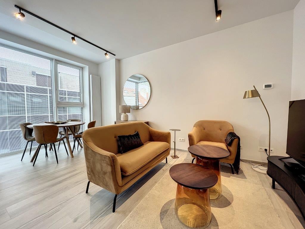 Salon moderne minimaliste avec fauteuils confortables, lumière naturelle, décoration élégante et espace dining.