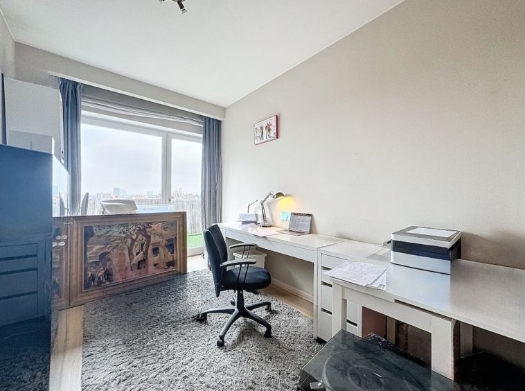 Bureau moderne avec vue urbaine, mobilier épuré, lumière naturelle et décoration élégante.