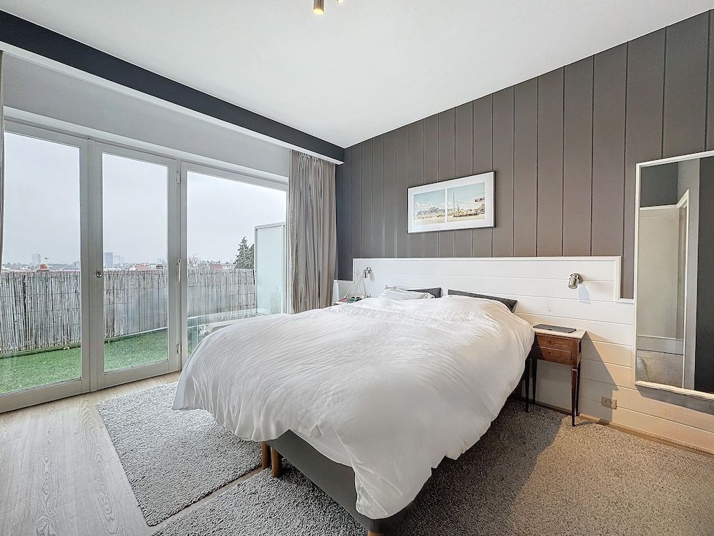Chambre moderne lumineuse avec grand lit, vue sur terrasse, décor minimaliste et ambiance apaisante.