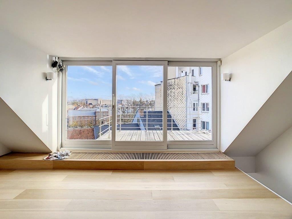 Salon moderne lumineux avec grande baie vitrée et vue urbaine, designMinimaliste, ambiance sereine.