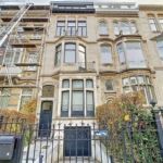 Immeuble parisien historique en rénovation avec échafaudages, balcons et façade en pierre claire.