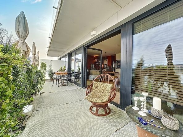Terrasse urbaine moderne, espace détente élégant avec vue, mobilier chic et plantes verdoyantes.