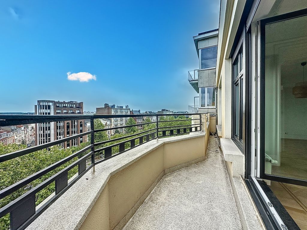 Balcon moderne offrant une vue urbaine panoramique sous un ciel bleu ensoleillé.