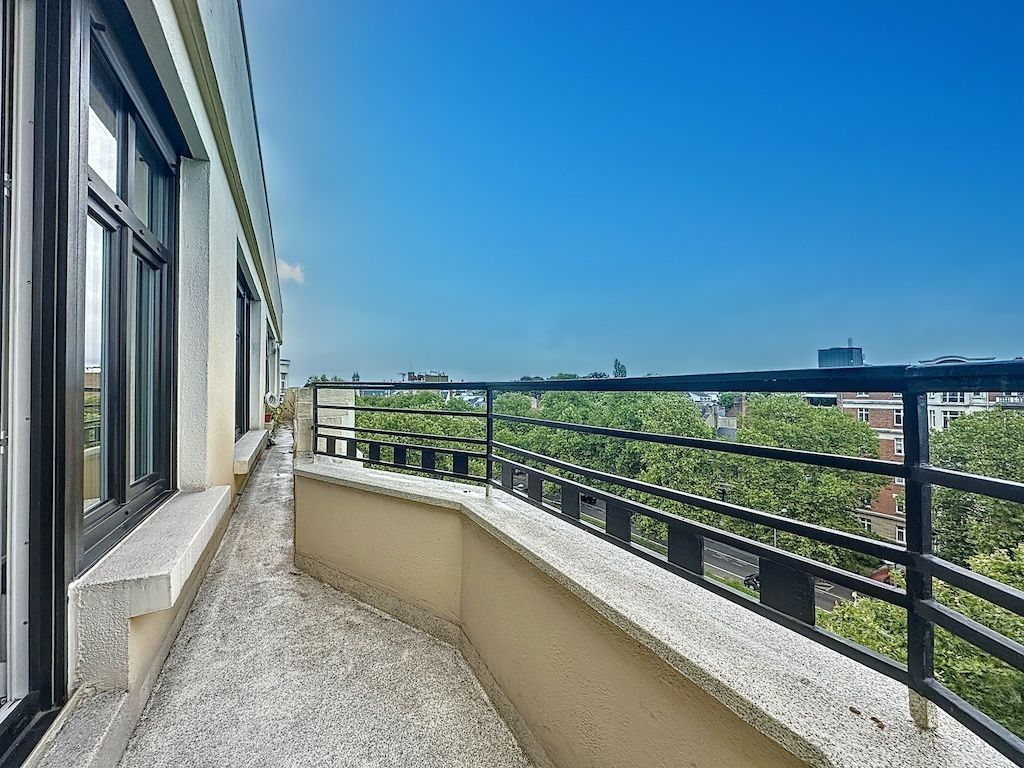 Balcon moderne en hauteur avec vue dégagée, grandes fenêtres, sol lumineux et ambiance conviviale.