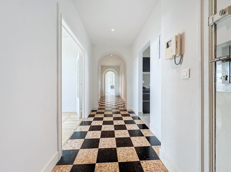 Couloir moderne avec sol checkered, arc élégant, lumineux, design contemporain et espace fonctionnel.