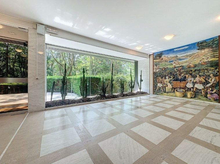 Intérieur moderne avec murale colorée, vue sur la nature et sol en pierre polie élégante.