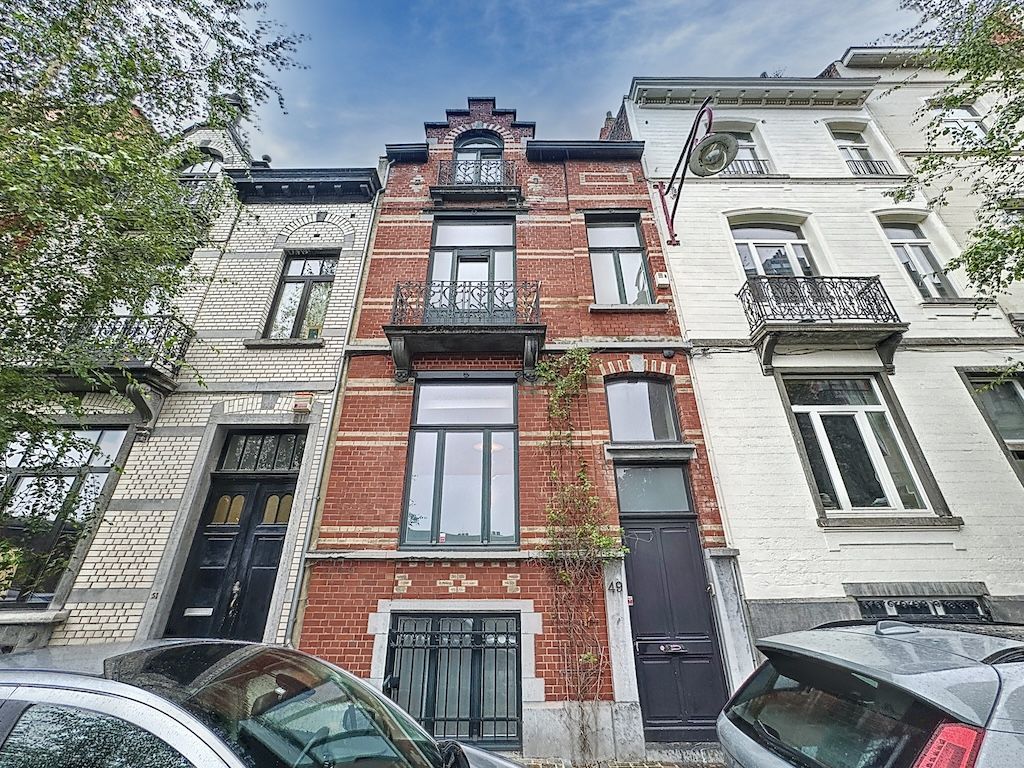 Rues urbaines avec maisons en brique, pierre, et modern style, entourées d’arbres et véhicules.