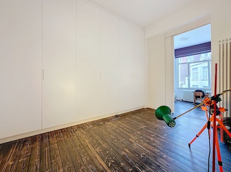 Salle minimaliste moderne avec vue urbaine, mobilier épuré, lampadaire vert et espace créatif.