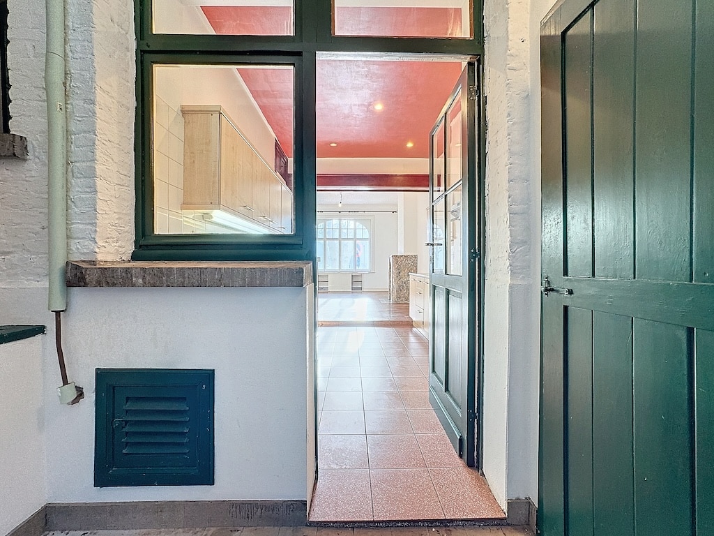 Entrée moderne avec porte en verre, ambiance chaleureuse et intérieur lumineux en style contemporain.