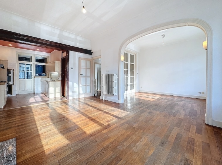 Espace lumineux avec plancher en bois, cuisine moderne et archways élégants pour décoration.