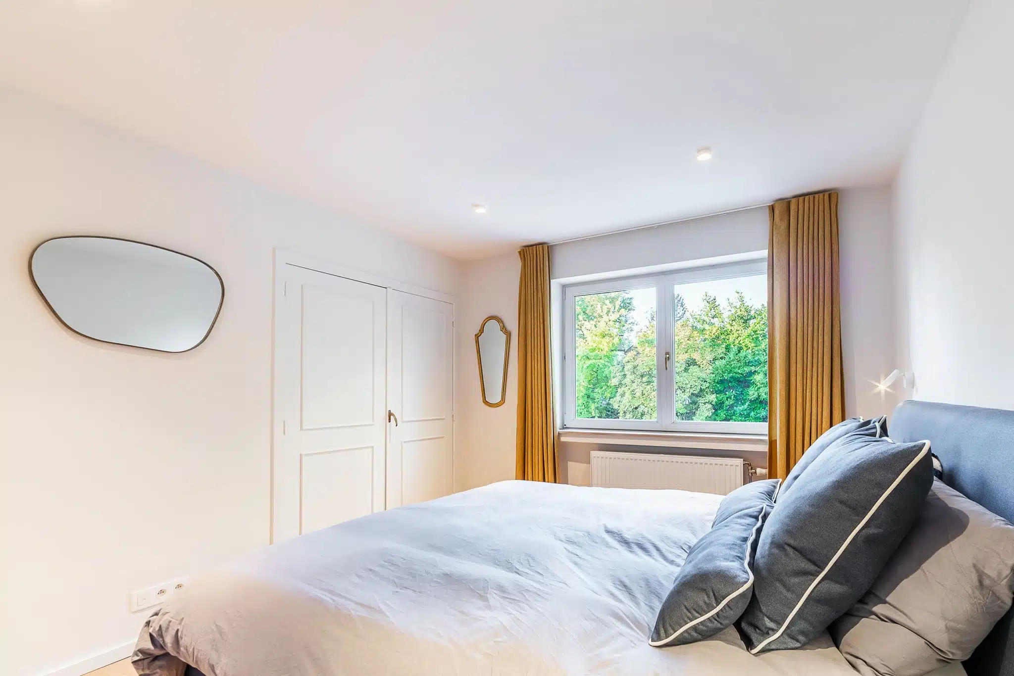 Chambre moderne et lumineuse avec vue sur la nature et décoration minimaliste élégante.