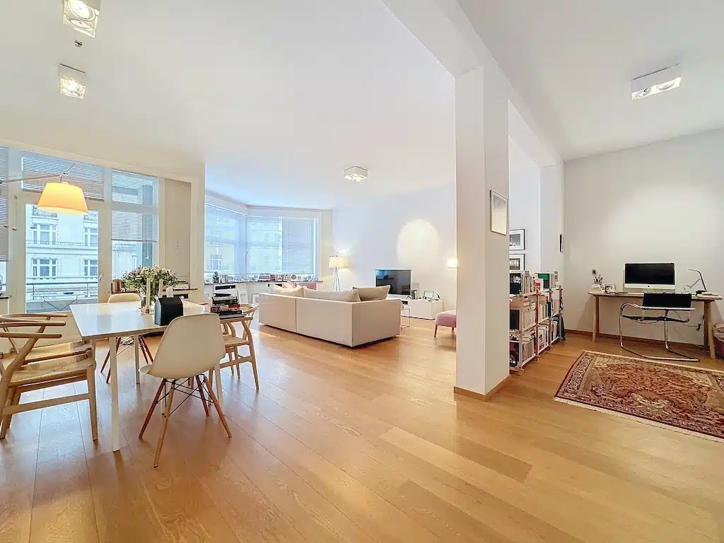 Intérieur contemporain chaleureux avec salon, coin repas lumineux et espace de travail multifonctionnel.