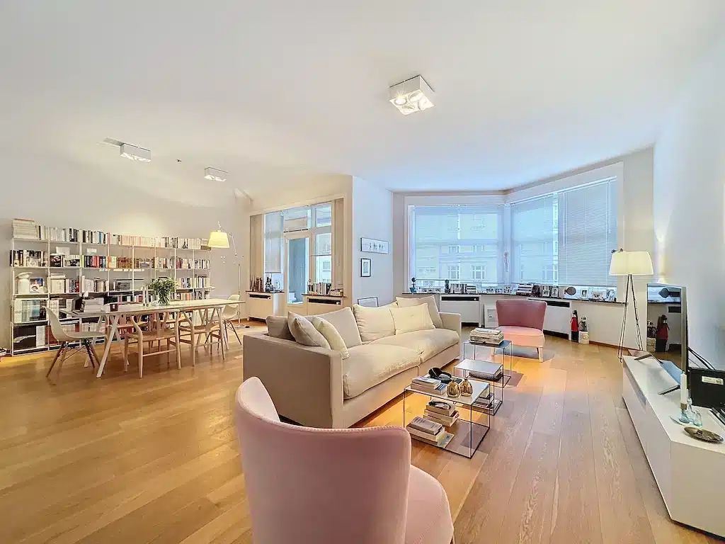 Salon contemporain lumineux avec mobilier pastel, espace ouvert, décoration chic et ambiance accueillante.