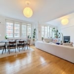 Salon lumineux moderne, mobilier élégant, plantes et lumière naturelle pour une ambiance chaleureuse.