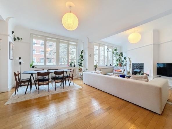 Salon lumineux moderne, mobilier élégant, plantes et lumière naturelle pour une ambiance chaleureuse.