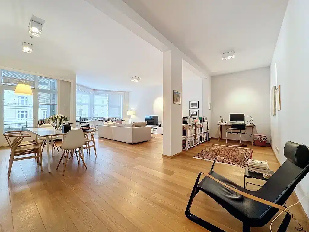 Salon moderne lumineux avec mobilier élégant, lumière naturelle, espace convivial et design épuré.
