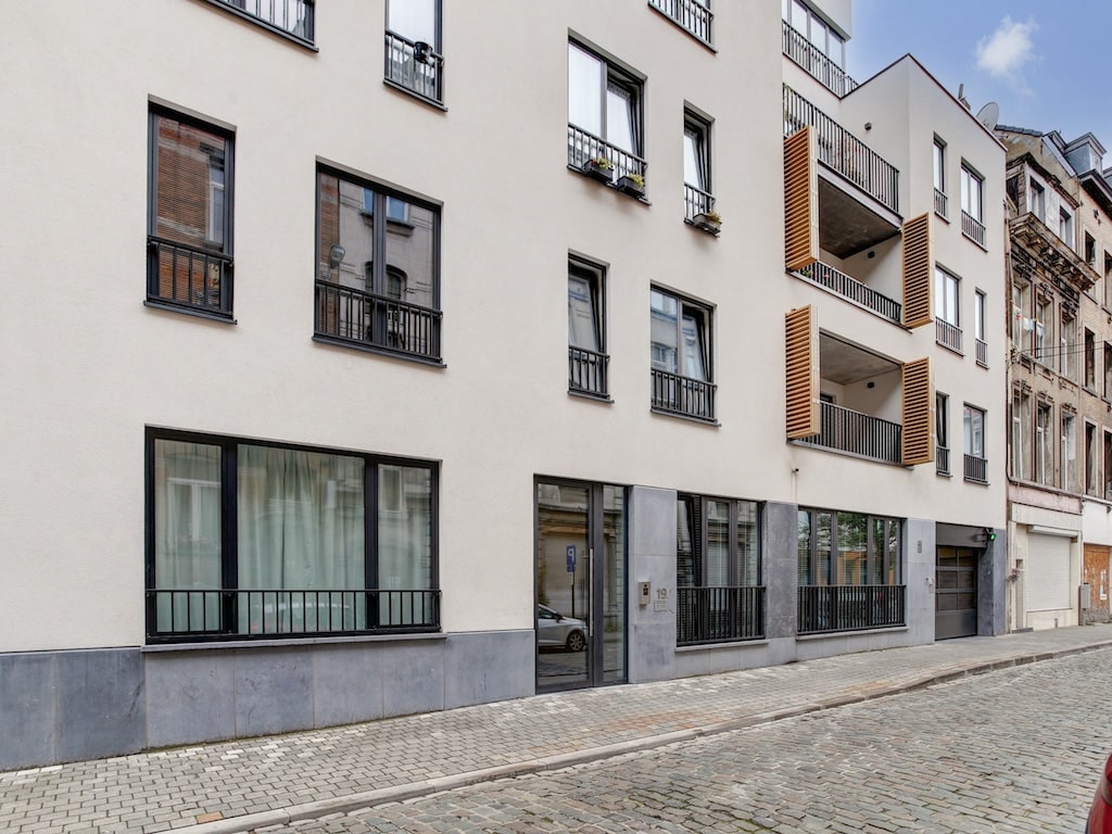 Appartement contemporain avec balcons en bois, parking et façade moderne en plein cœur de Bruxelles.