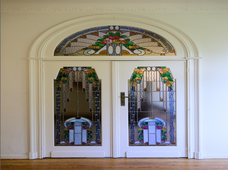 Double porte en verre coloré avec motifs floraux, entrée élégante et lumineuse.
