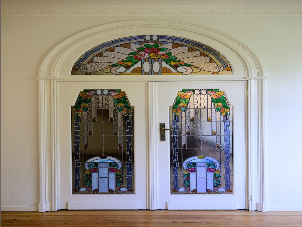 Double porte en verre coloré avec motifs floraux, entrée élégante et lumineuse.