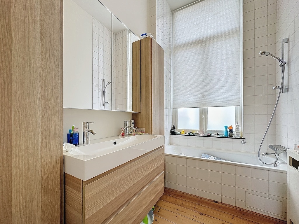 Salle de bain moderne minimaliste avec bois chaleureux, lumière naturelle et espace élégant et fonctionnel.