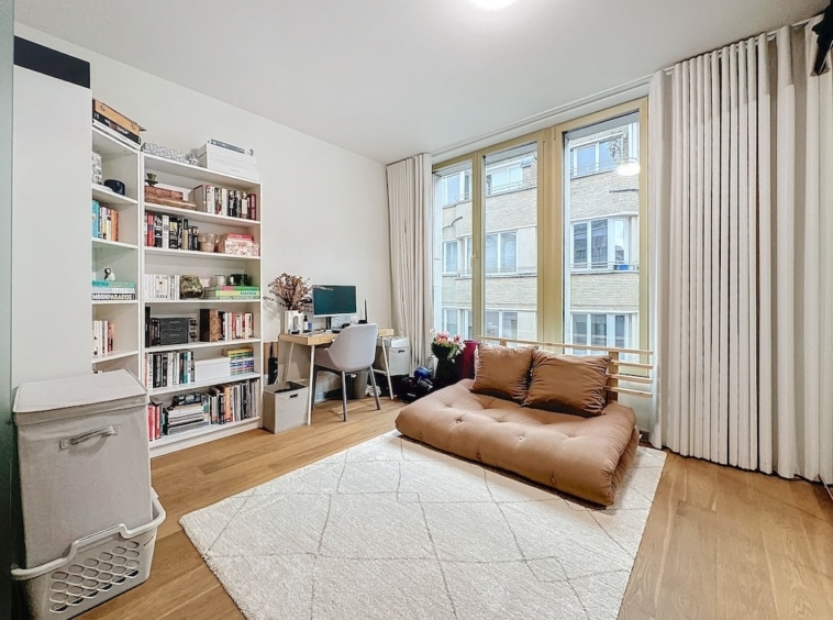 Salon douillet avec bibliothèque, espace de lecture et coin détente lumineux.