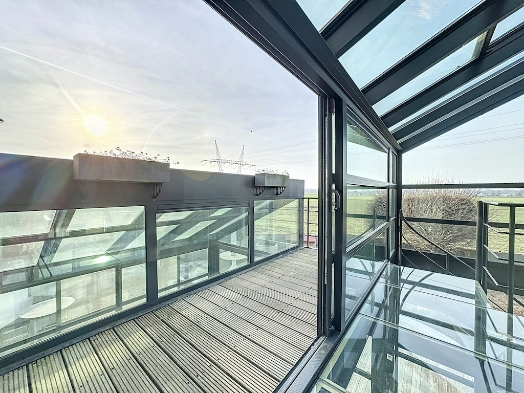 Balcon en verre contemporain avec vue panoramique, lumineux et élégant, idéal pour se détendre et profiter de la nature.