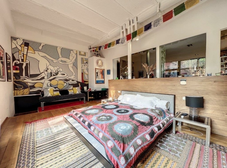 Chambre moderne chaleureuse avec fresque murale colorée, lit confortable, tapis décoratif et lumière naturelle