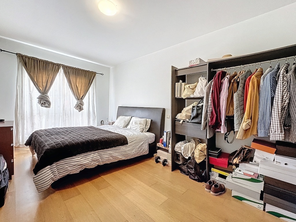 Chambre moderne lumineuse avec lit cosy, rangement organisé et décoration épurée.