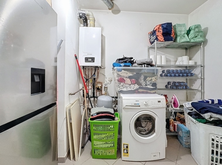 Coin buanderie moderne avec électroménagers, rangement organisé et espaces de lavage fonctionnels.