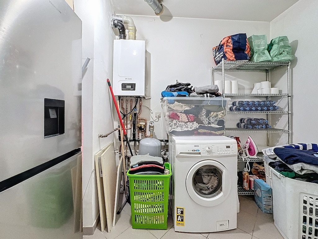 Coin buanderie moderne avec électroménagers, rangement organisé et espaces de lavage fonctionnels.