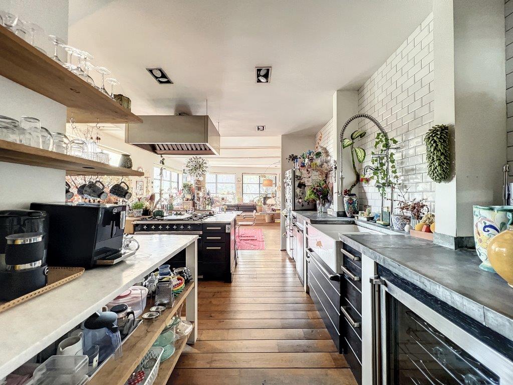 Cuisine moderne avec meubles en bois, rangements modernes, lumière naturelle, design élégant et chaleureux.